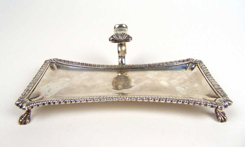 A George III silver hallmarked snuffer tray of waisted form with scroll over handle and gadrooned