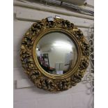 An ornate gilt framed convex mirror