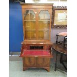 A reproduction mahogany secretaire bookcase with two glazed doors over secretaire drawers and two