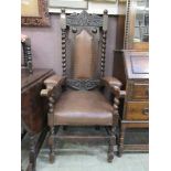 An early 20th century oak framed high back open armchair with Greenman mask to cresting rail