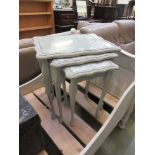 A nest of three grey painted occasional tables