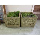 A pair of composite stone garden planters with floral design