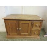 A pine cabinet having two cupboard doors along side two drawers