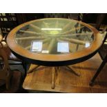 A 1980's circular topped coffee table in the form of a wheel covered by glass