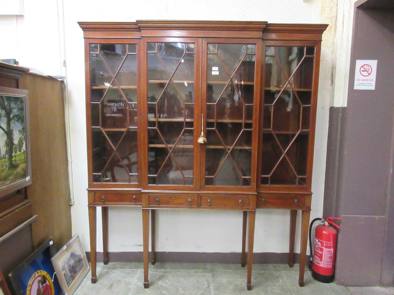 An Edwardian mahogany and strung breakfront display cabinet, the cornice over four astragal glazed