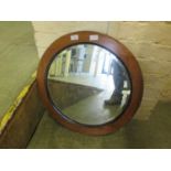 An early 20th century oak framed circular bevel glass mirror