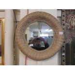 A wicker framed circular mirror