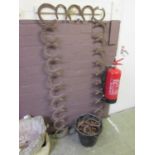 A frame made of metal horseshoes along with a bucket of loose horseshoes