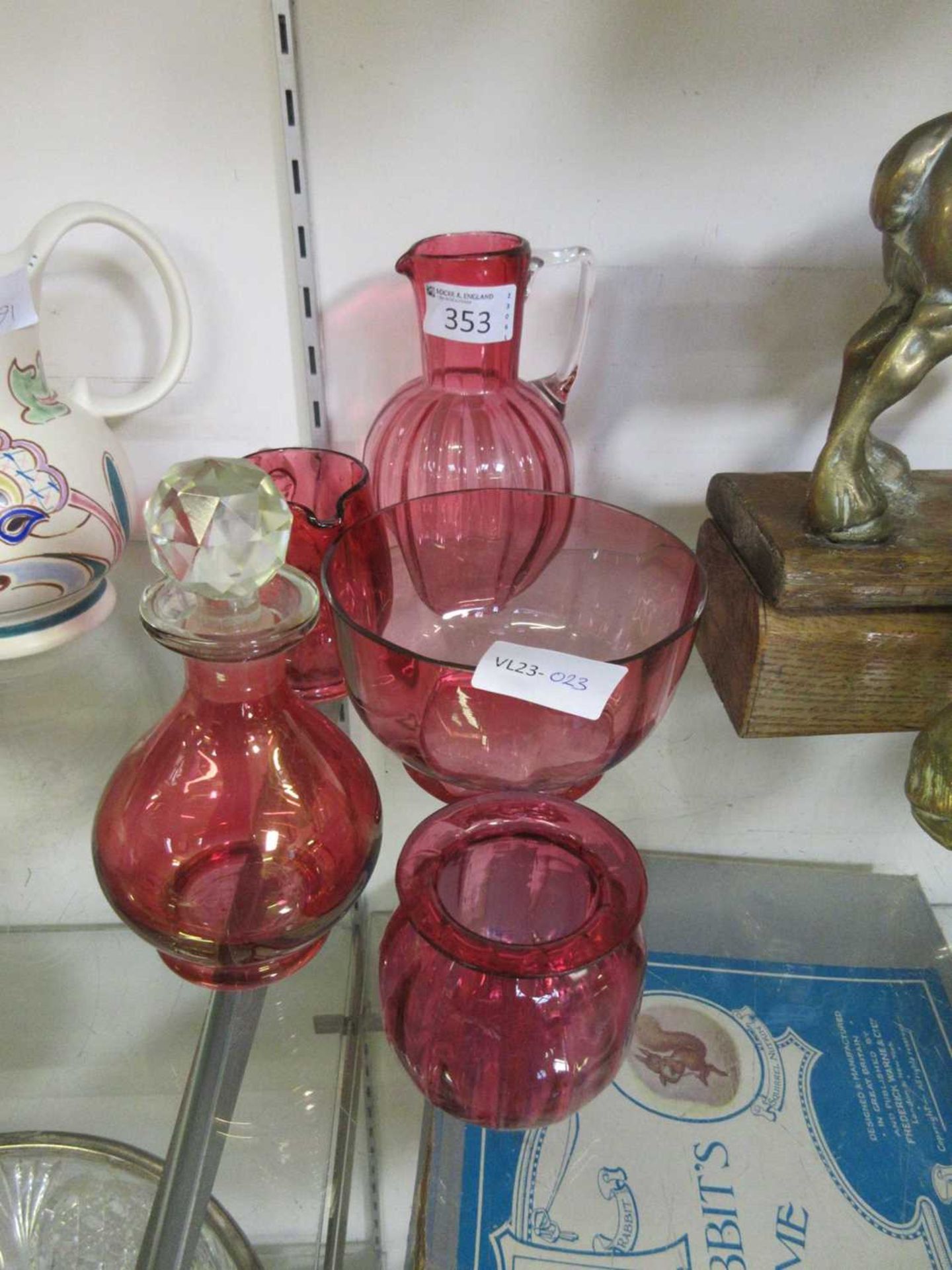 Five items of cranberry glassware to include pouring jugs and bowls