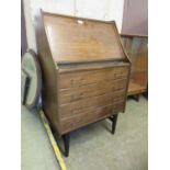 A mid-20th century mahogany bureau, the fall front over four long drawers on ebonised tapering legs