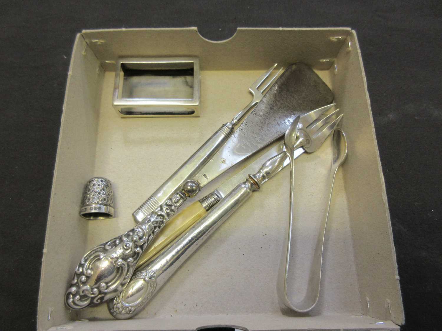 An assortment of silver hallmarked and white metal items to include matchbox holder, fork,