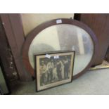 An oval bevel glass mirror along with a black and white print of workmen