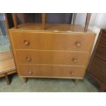 A mid-20th century oak veneered chest of three drawers