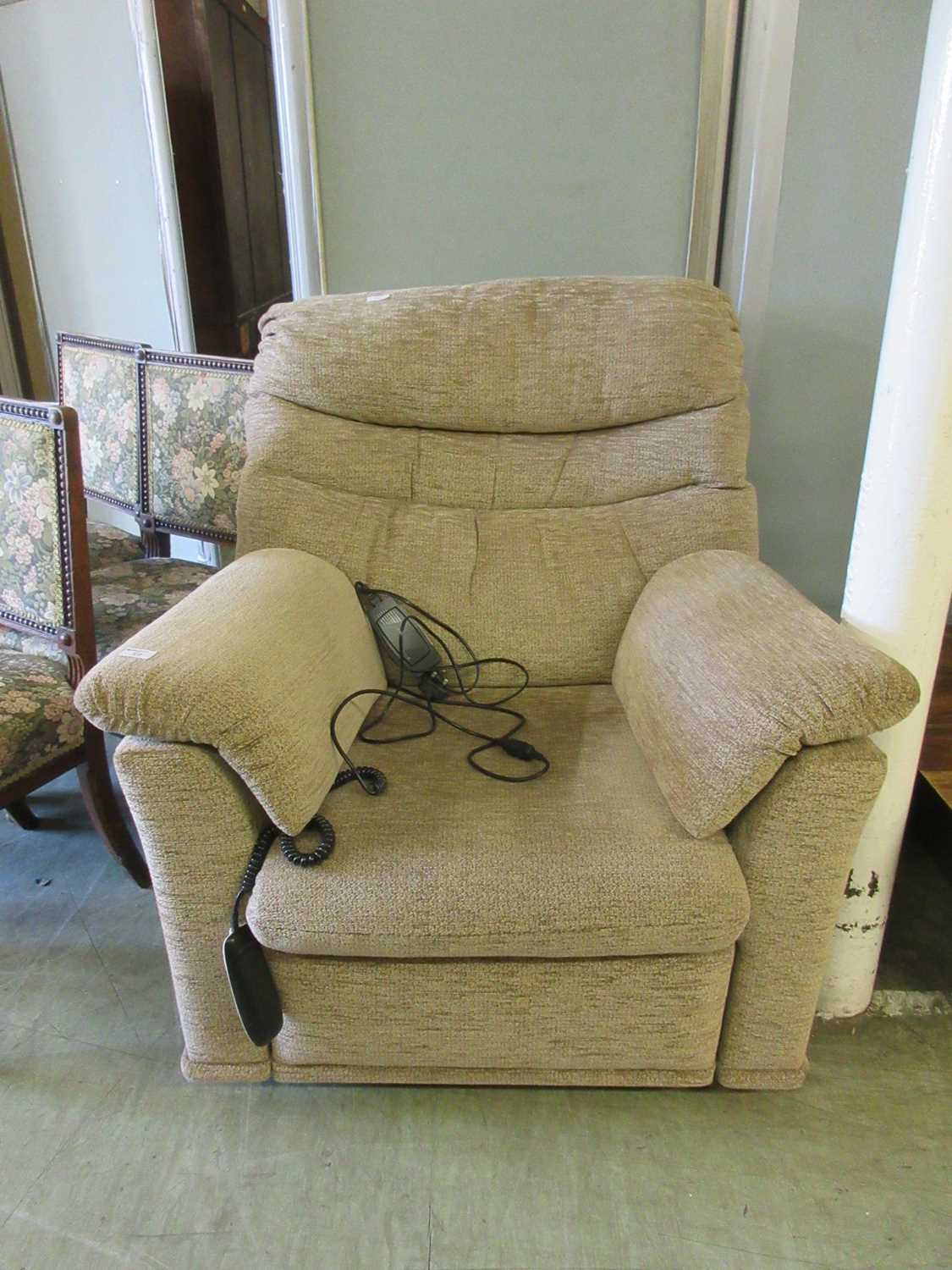 An electric rise and recline chair upholstered in a cut brown fabric