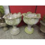 A pair of composite garden urns with floral design bodiesRepaired crack to one pot, likely needs