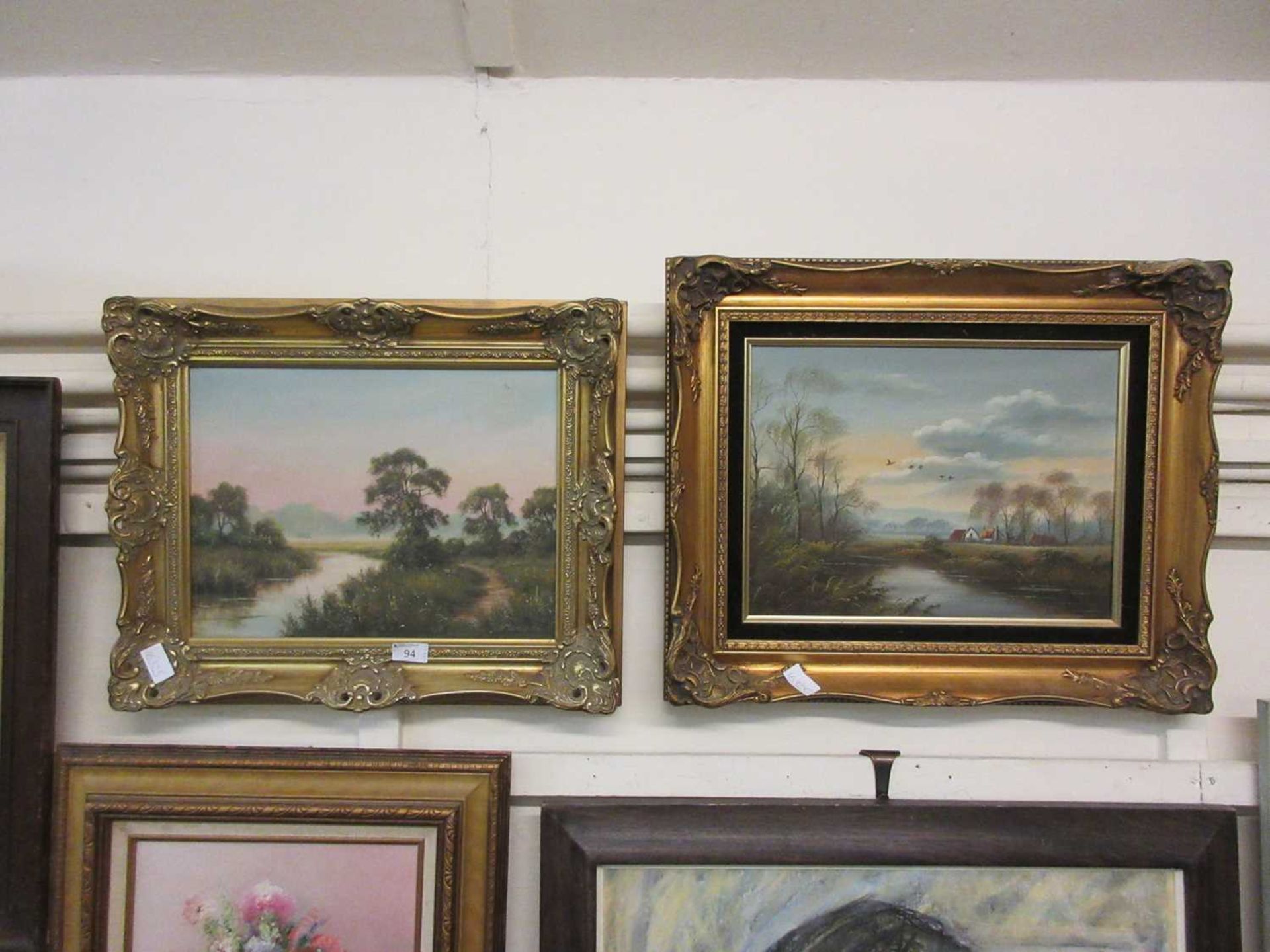 Two ornate gilt framed oil paintings of countryside