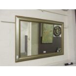 A silver and gold framed rectangular mirror