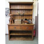 A 19th century and later pine dresser, the plate rack over base with two drawers and open storage