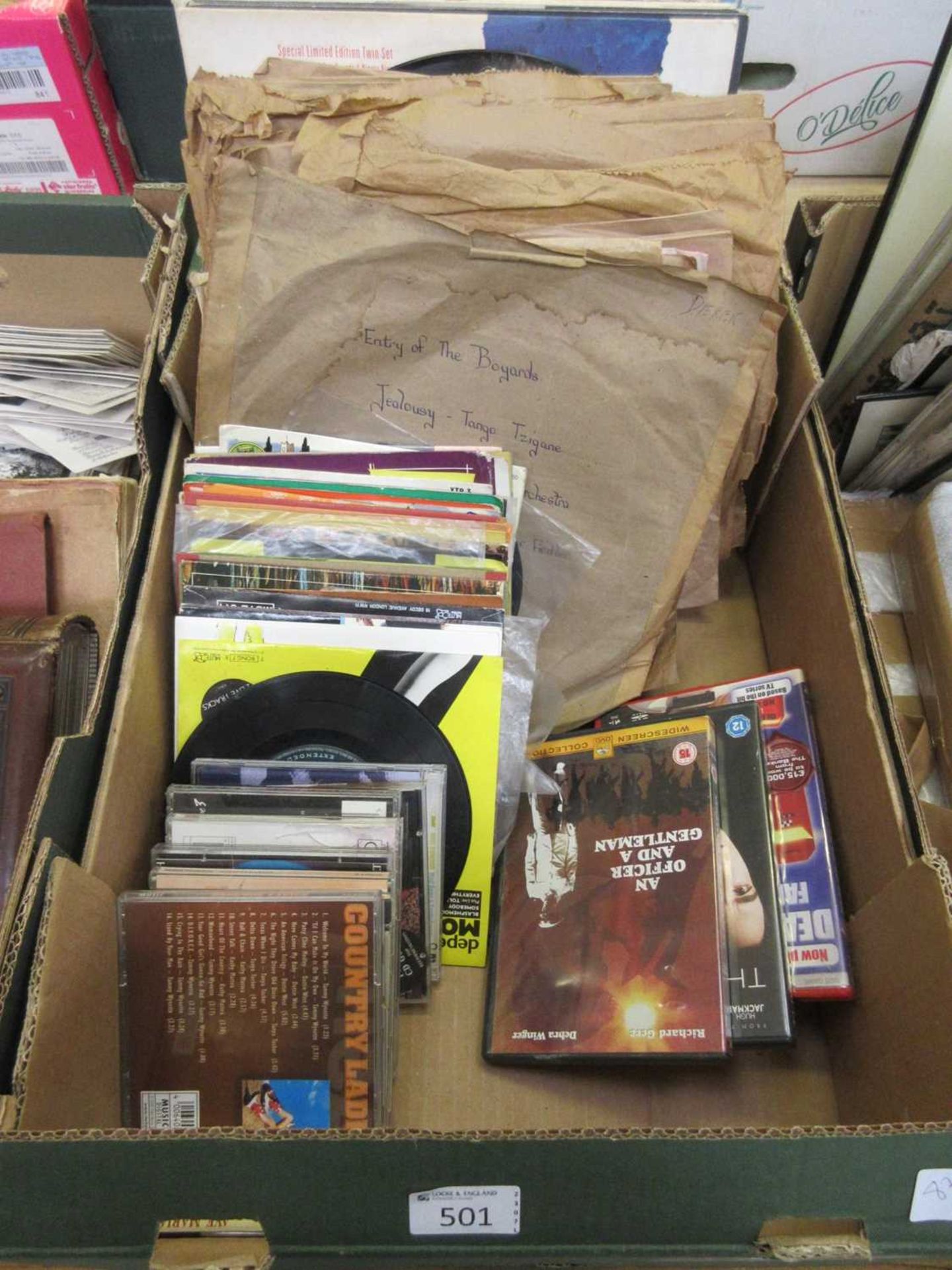 A tray containing a quantity of records, DVDs, CDs, etc