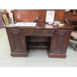 A late 19th century walnut breakfront desk with carved panels and drawer