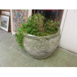A composite stone garden pot with a quantity of greenery