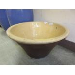 A dough bowl with yellow glazed interior