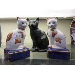 A pair of continental ceramic sitting cats along with one other