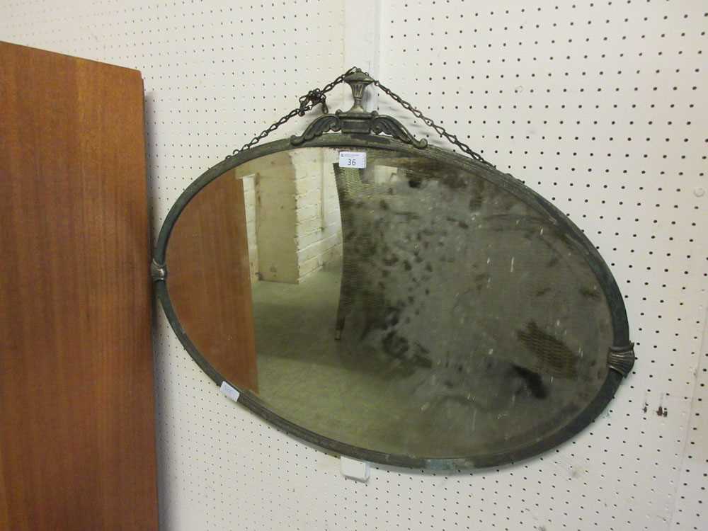 An early 20th century metal framed bevel glass oval mirror