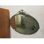 An early 20th century metal framed bevel glass oval mirror