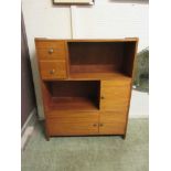 A mid-20th century teak storage unit with drawers, shelves, and cupboard doors