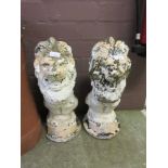 A pair of composite stone garden ornaments in the form of seated lions