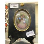 A framed and mounted hand painted oval plaque of young girl in pink dress