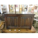 A reproduction oak blanket box with linen fold panels