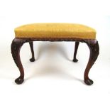 An early 20th century 18th century style walnut stool upholstered in a patterned yellow fabric,