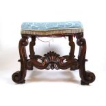A 19th century Italian lacquered walnut stool. the seat on carved scroll legs joined by S-scroll