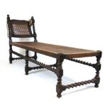 An early 18th century style walnut day bed, the adjustable end with carved cresting rail on barley