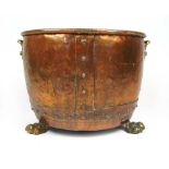 An early 19th century brass and copper log bin, the riveted body with carry handles on three paw