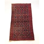 A handwoven Turkish rug, the triple line border surrounding the blue ground field with serrated leaf