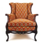A 19th century French walnut framed armchair upholstered in a floral cut fabric, the humpback and