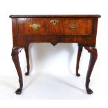An early 18th century walnut side table, the quarter veneered, banded top with re-entrant corners