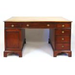 An early 20th century mahogany partners desk, the top with tooled yellow leather inset above the
