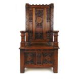 A 19th century oak Gothic throne chair, the castellated top over the carved back with armorial crest
