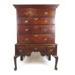An 18th century and later oak chest on stand, the cavetto cornice over two short and three long