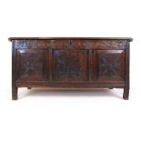 An early 18th century oak coffer, the moulded top lifting to reveal a vacant interior over the later