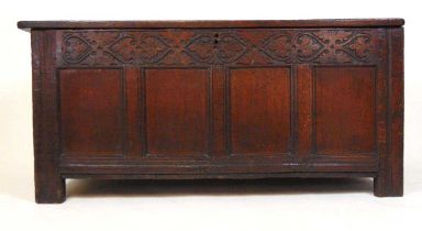 A late 17th century oak coffer, the four panel top lifting to reveal a vacant interior over the