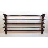 A 19th century carved oak wall hanging plate rack with carved head finials, h. 70 cm, w. 131 cm