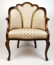 An early 20th century mahogany and strung tub chair upholstered in a floral patterned fabric, the