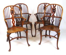 A set of four early 20th century elm, ash and yew Windsor chairs, the comb back with shaped and