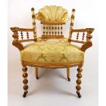 An early 20th century giltwood armchair upholstered in a floral gold fabric, the shell upholstered