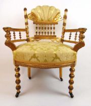 An early 20th century giltwood armchair upholstered in a floral gold fabric, the shell upholstered